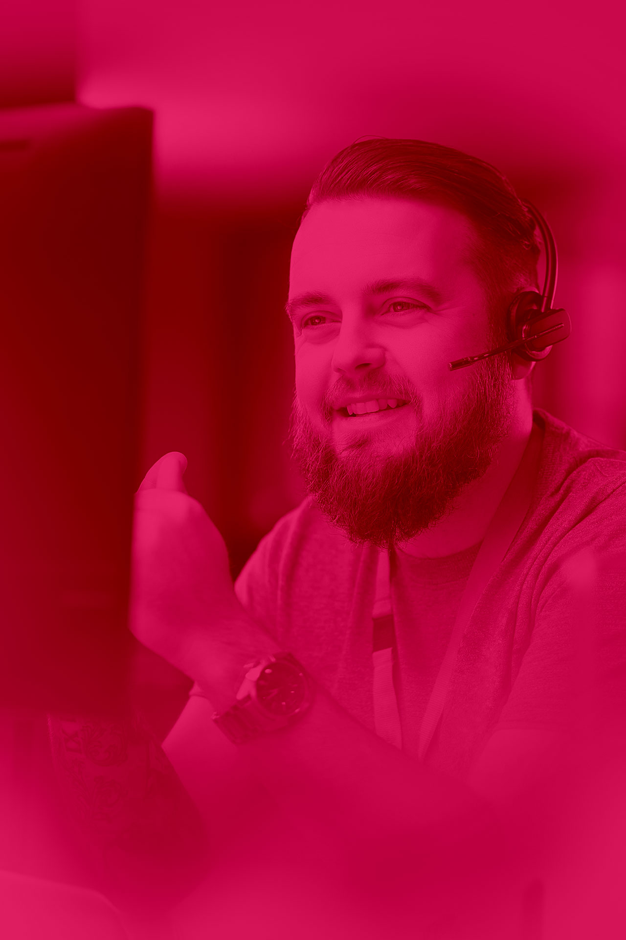 Male professional in a vibrant office environment, focused on a computer screen, working on technical support or software development.